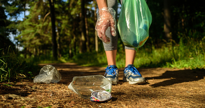 девушка собирает мусор в лесу фото