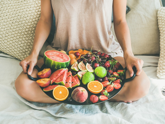 девушка держит поднос с фруктами фото