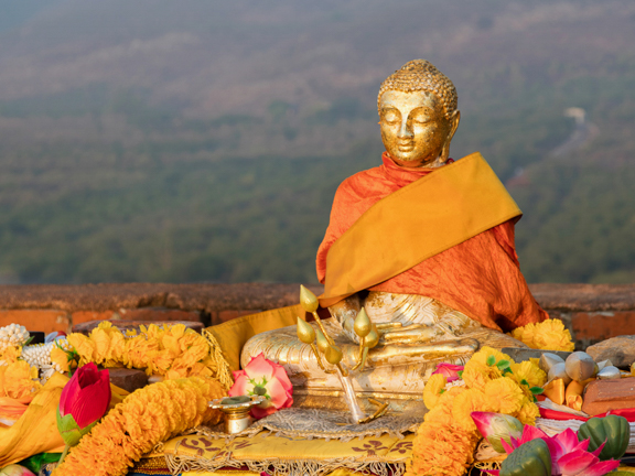 статуя будды в цветах