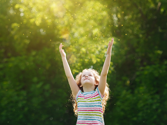 девочка подняла руки к лучам солнца