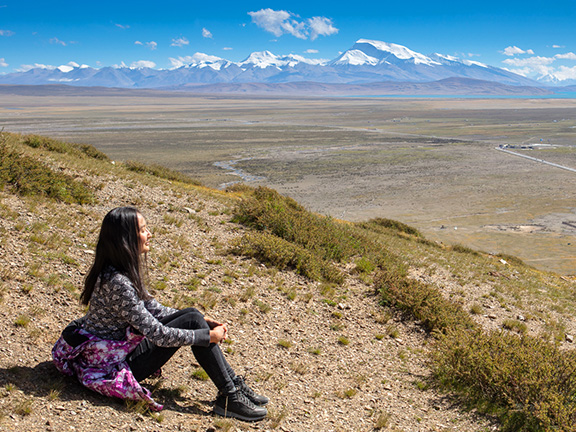 девушка сидит в горах
