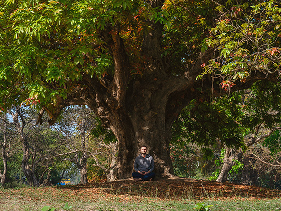 мужчина медитирует на природе