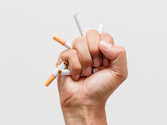 рука сминает сигареты