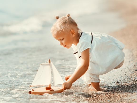 девочка играет с парусником