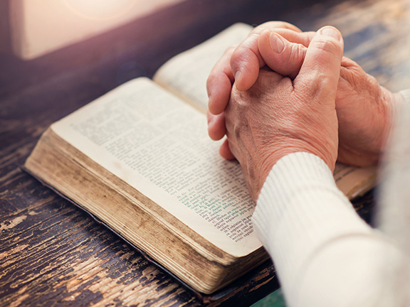 человек молится на книге