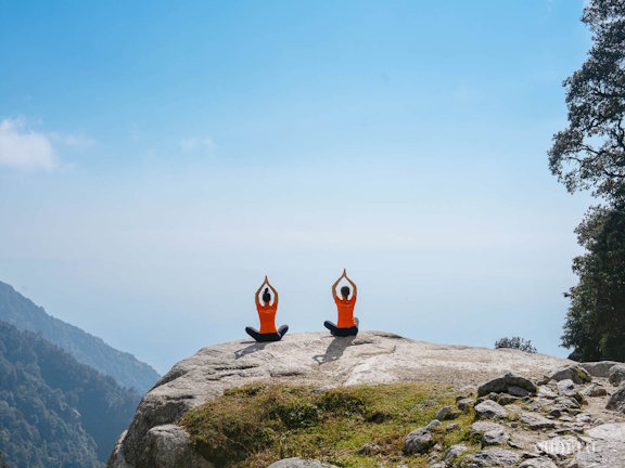 Две девушки в позе лотоса на скале