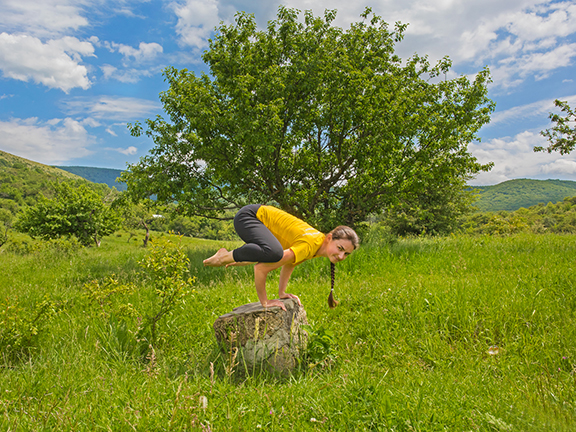 девушка на пеньке в бакасане, бакасана на природе