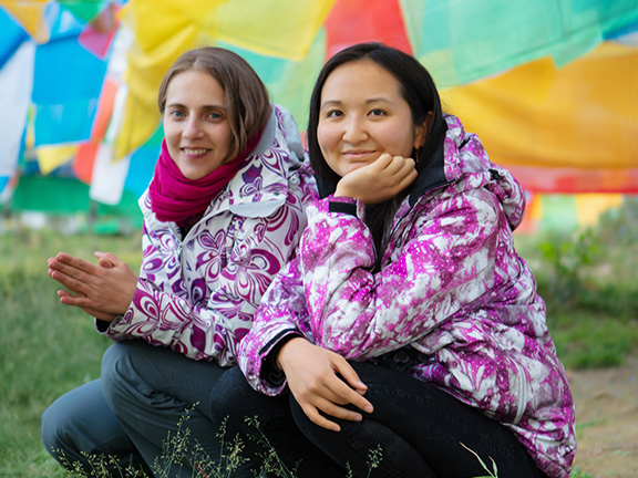 две девушки рядом с тибетскими флажками