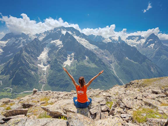 Девушка сидит в позе лотоса в горах