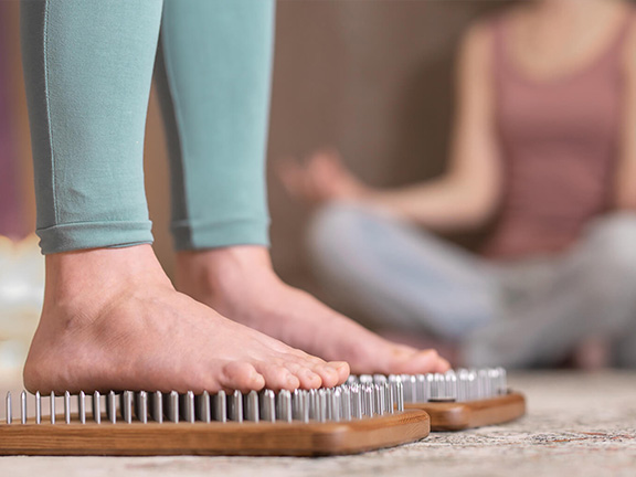 ноги на доске с гвоздями