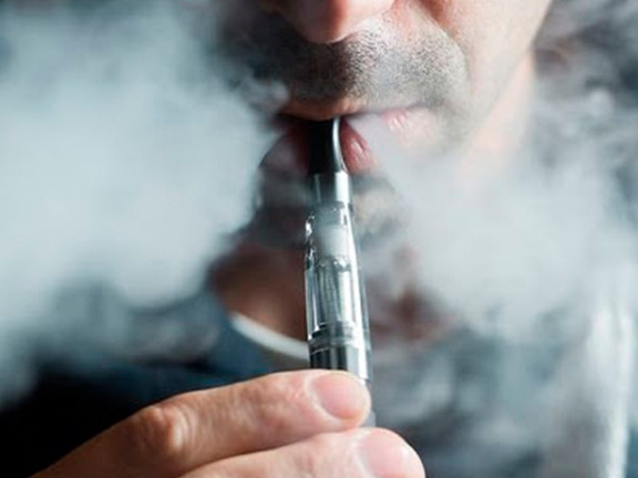 мужчина курит электронную сигарету