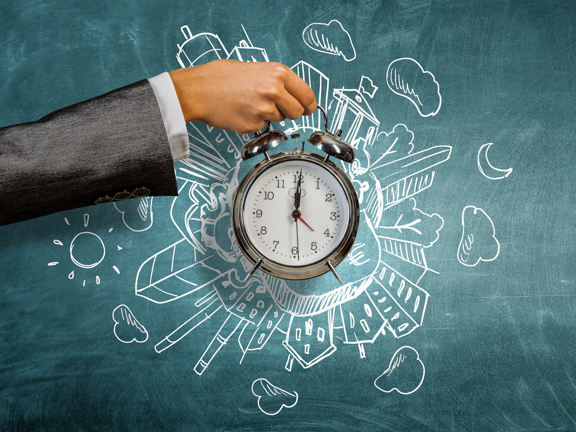 мужская рука держит будильник