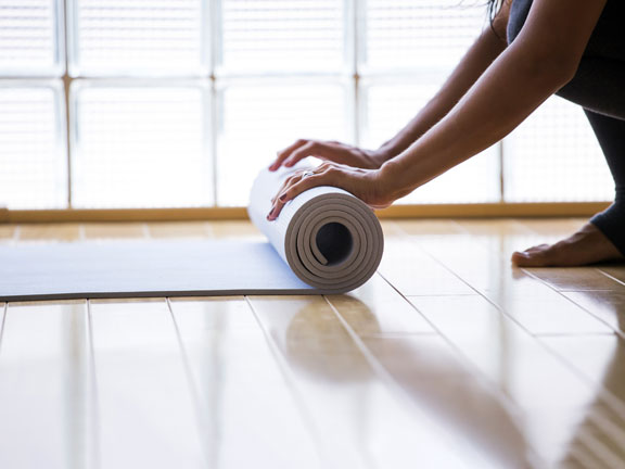 девушка раскатывает коврик