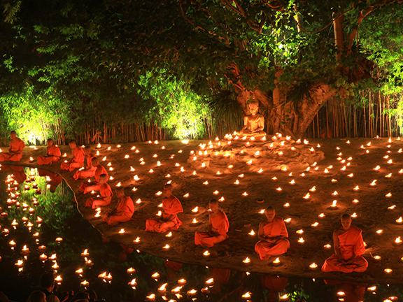 буддийские монахи медитируют со свечами