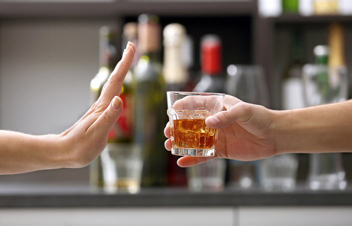 рука отвергает стакан с алкоголем