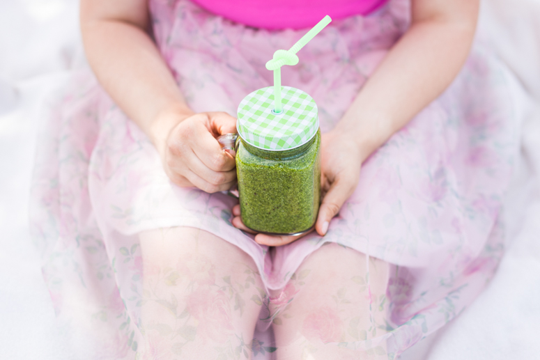 close-up-of-young-woman-holding-green-smoothies-PWE4EN6.jpg