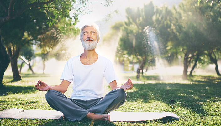 мужчина занимается йогой на природе