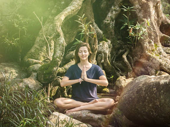 девушка медитирует под деревом