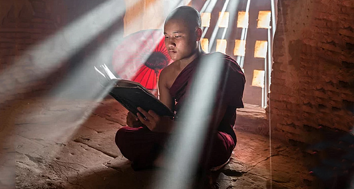 буддийский монах читает книгу