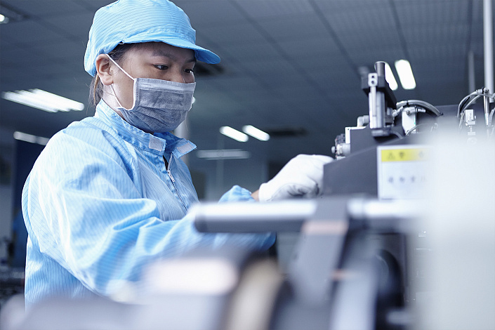 Работник на заводе изготавливает устройство фото