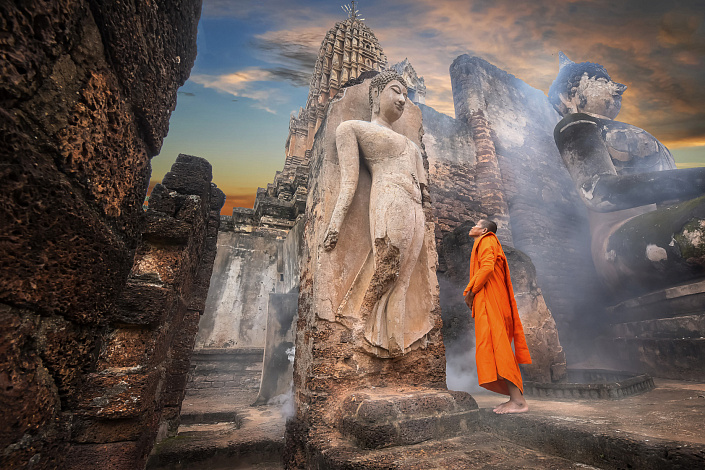 монах смотрит на статую будды фото