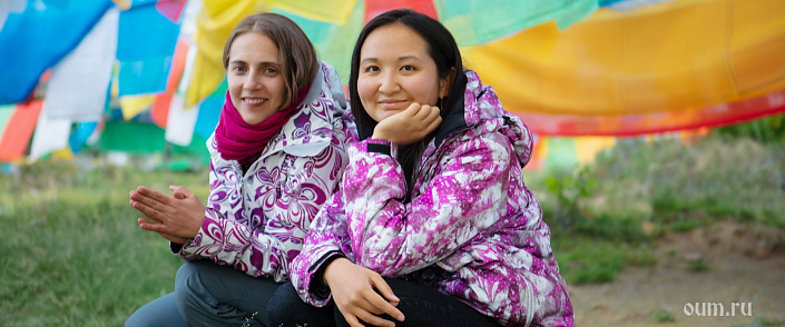 две девушки рядом с тибетскими флажками