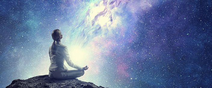 девушка медитирует на фоне звездного неба