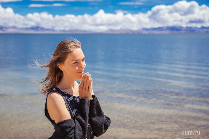 Девушка у озера, ладони в намасте