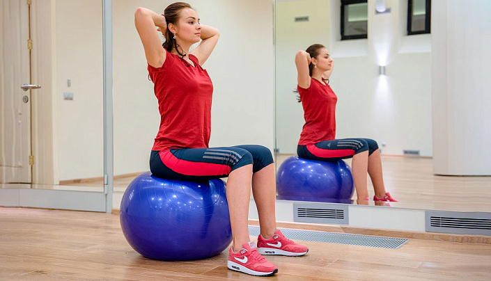 девушка занимается на фитболе